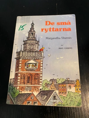 De små ryttarna - En spännande och gripande berättelse om Johanna, en amerikansk tjej i Holland under ockupationen. Hon och hennes farfar måste rädda de små ryttarna i kyrktornets klockspel. En bok om mod, oväntad hjälp och att våga se varje människa för den de är.