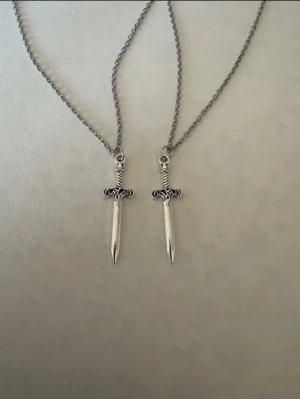 Silverhalsband x2 mindre svärd - Perfekta julklappen 🌲  Säljer smycken som skapats som hobby av mig och dottern.   Halskedjor är 50cm.  Bilder på berlock kan vara missvisande så är det viktigt så fråga gärna om mått 🌹  Smycken är inte av äkta guld/silver .   Inga bud godtas då priserna är så billiga❤️