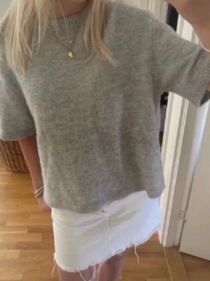 Grå stickad tröja med kort ärm - Oversized stickad tröja. Avklippta lappar men i storlek S
