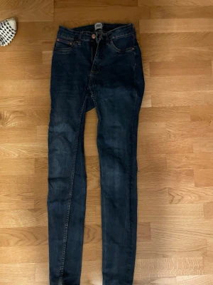 Mörkblå skinny jeans från 157 - Mörkblå jeans med skinny fit från 157. Klassisk femficksmodell med knapp och dragkedja i midjan. Jeansen har en smal passform och är tillverkade i stretchigt denimtyg för extra komfort.