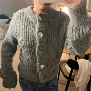 Grå kofta i alpackablandning H&M XS - Supermysig grå kofta från H&M i alpackablandning med stora guldiga knappar framtill. Mycket fint skick! Nypris ca 800