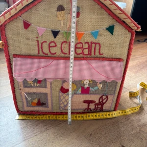 Handgjord förvaringslåda Ice Cream - Charmig handgjord förvaringslåda i form av en glasskiosk. Broderade detaljer, färgglada applikationer och praktiskt lock. Något slitage på kanter och viss tråd har lossnat, men i gott skick för förvaring av leksaker eller barnrumsinredning. 2 lite större liknande förvaringslådor kommer strax komma ut här, men är dock i lite mer använt skick och behöver lite kärlek med nål och tråd