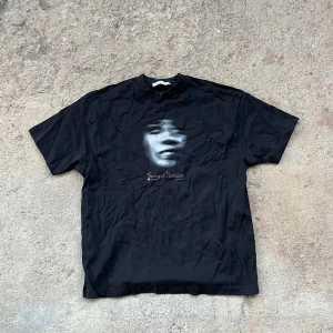 T-shirt Our Legacy  - Svart t-shirt från Our Legacy med ett konstnärligt tryck av ett ansikte och texten 'Swing of Pendulum' på bröstet. PRISET GÅR ATT DISKUTERAS VID SNABB AFFÄR🙌