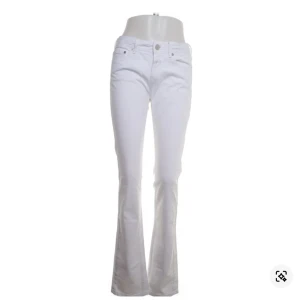 Vita bootcut jeans från Closed, stl 42 - Snygga vita jeans från Closed i bootcut-modell. Byxorna har klassisk femficksdesign, låg midja och är tillverkade i ett mjukt bomullstyg. Perfekta för dig som vill ha en fräsch och stilren look.