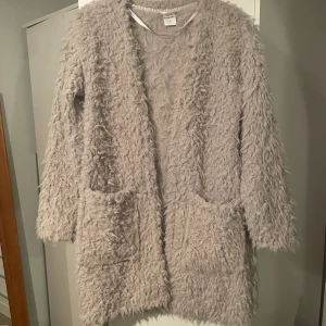 Beige teddyjacka från KappAhl S - Supermjuk och fluffig beige teddyjacka/ kofta från KappAhl i storlek S. Jackan har lång ärm, två stora fickor framtill.
