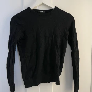 Svart stickad tröja från Uniqlo - En svart, klassisk stickad tröja från Uniqlo i storlek xxs. Tröjan har rund halsringning, sitter tajt och långa ärmar