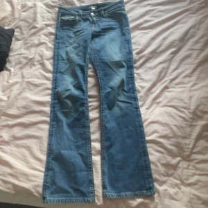 Blå bootcut jeans från Gina Tricot - Snygga blå jeans från Gina Tricot i bootcut-modell. Jeansen har klassisk femficksdesign, knapp och dragkedja framtill samt en ficka med lock bak. Tillverkade i jeansmaterial med cool tvätt och kontrastsömmar. Dem var för korta på mig så jag säljer vidare❤️