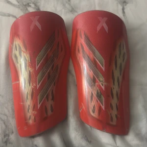 Adidas benskydd - Röda snygga adidas benskydd som funkar perfekt för din idrott. Skyddar dig väldigt bra med en bra kvalitet.