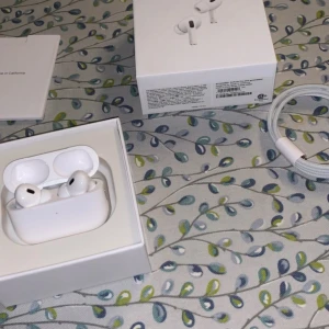 AirPods Pro (2nd generation) - Säljer ett par Apple AirPods Pro (2nd gen) i mycket fint skick. Komplett med kartong, laddningskabel och manual. Hörlurarna och laddningsfodralet ser ut som nya, inga synliga repor eller slitage. Perfekt för brusreducering och trådlös musikupplevelse.
