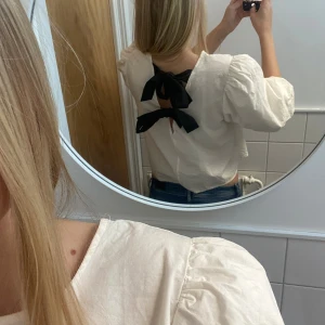 Supersöt vit blus med svarta rosetter bak🫶🏻💗 - Säljer min söta vita blus med puffiga ärmar🫶🏻 Den har svarta rosetter på baksidan🫶🏻Superfin nu till hösten💗skriv för mer frågor & bilder💗