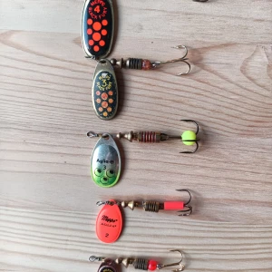 Mepps Spinnare Set - Snyggt set med 5 Mepps spinnare i olika storlekar och färger, inklusive Black Fury och Aglia-modeller. Perfekt för fiske efter regnbåge. Spinnarna är i gott begagnat skick, med mindre tecken på användning. Levereras i praktisk plastask.