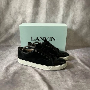 Svarta sneakers från Lanvin - Tjena, säljer nu ett par svarta lanvins i storlek 45. Allt og medföljer (nya snören, dustbag, box). Finns en liten defekt på tåboxen vilket man kan se på bild nummer 3. Sulkräm har använts för uppfräschning av skorna.