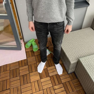 Svarta nudie jeans med slitningar - Snygga svarta jeans med slitningar och skön tvätt från nudie i modellen lean dean. Inga deffekte utöver slitningarna. Storlek 29/34 men skulle säga att de även passar 30/34. Bara att skriva vid frågor eller funderingar!