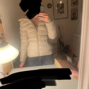 Ljusbeige pufferjacka från polo - Säljer en ljusbeige pufferjacka från polo med huva och dragkedja framtill.