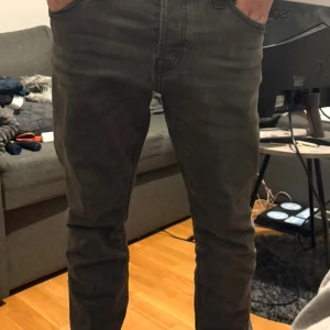 Grå jeans från Jack and Jones 31/30 - Säljer ett par grå jeans från Jack and Jones  i storlek 31/30. Jeansen har klassisk femficksdesign, raka ben och diskreta sömmar på bakfickorna. Snygg tvättad grå färg som passar till det mesta. Perfekta för dig som gillar stilrena och moderna jeans.
