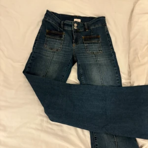 Jeans med fickor - Snygga blå jeans från Nelly med stora framfickor och klassiska bakfickor. Jeansen har raka ben och markerade sömmar framtill. Perfekta för dig som gillar en avslappnad men trendig look.