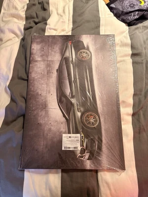 Tavla med BMW M5 (stl 60/40)cm - Snygg tavla med motiv av en mörkgrön sportbil mot en mörk bakgrund. Rektangulär form och inramad med svart ram. Perfekt för dig som gillar bilar och vill ha något coolt på väggen. Materialet är canvas och ramen är i trä.