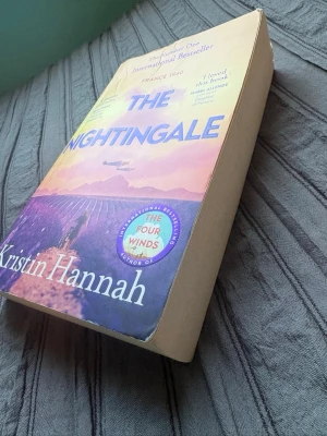 The Nightingale av Kristin Hannah - En gripande roman på engelska, 'The Nightingale' av Kristin Hannah. Perfekt för dig som gillar starka berättelser om mod och kärlek under andra världskriget.