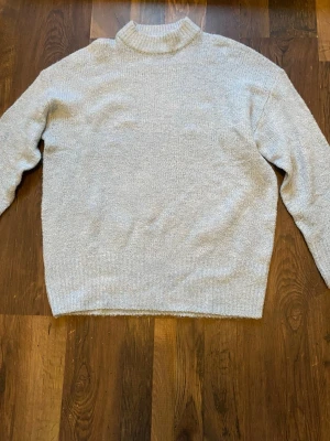 Ljusblå stickad tröja - Lång stickad tröja, ljusblå. Genomskinlig, så man kan ha något linne under.