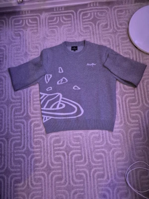 Grå stickad tröja med design. - Grå stickad tröja med design från Broken Planet.