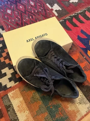 Mörkblå sneakers från Axel Arigato - Clean 90s från Axel Arigato. Färgen är mörkblå. Har använt flitigt i ungefär 2 år men nu har de suttit i garderoben lite för länge. De är tillverkade i mocka. Hundhår kan förekomma. Pris kan diskuteras
