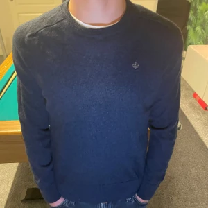 Mörkblå stickad tröja från Morris - Säljer en mörkblå stickad tröja från Morris med deras klassiska lilje-brodyr på bröstet. Tröjan är storlek xl barn. Tröjan har rund halsringning och långa ärmar, perfekt för lager-på-lager under höst och vinter. Enkel och stilren design som funkar till jeans eller chinos. Bara att höra av sig vid fler frågor🤗 
