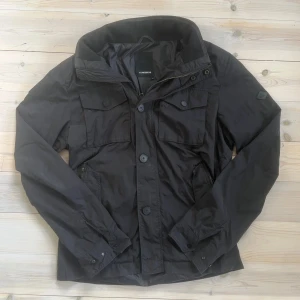J.lindeberg field jacket - En riktigt fet och trendig jacka från J.Lindeberg. Jackan har inga större defekter. Det enda som syns är att dragkedjorna har använts rätt så mycket och därför framstår lite guldiga. Längst ner ser det ut som det saknas ett knapp också, vet däremot inte om detta stämmer då det inte ser ut som att det suttit en knapp där tidigare (men ett hål till en knapp är där), kan vara till extraknappar att sy på. Detta är inget som man tänker på dock. Nypris: ca 4000kr. Skick: 8/10