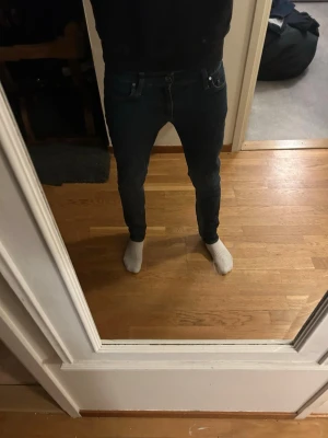 Mörkblå skinny jeans från tiger of Sweden  - Säljer ett par mörkblå skinny jeans från tiger of Sweden . Klassisk femficksmodell med smal passform och låg midja. Jeansen är i stretchigt bomullsmaterial och har diskreta slitningar för en snygg look. Perfekta till vardags och matchas lätt med olika stilar.