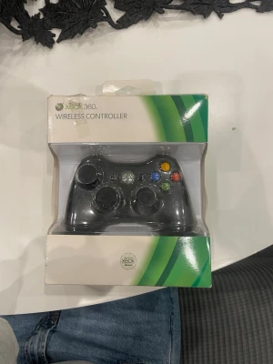 Xbox 360 trådlös handkontroll svart - Säljer en svart trådlös handkontroll till Xbox 360. Klassisk design med två analoga spakar, styrkors och färgade knappar (A, B, X, Y). Tillverkad i plast och passar perfekt för gaming på Xbox 360.