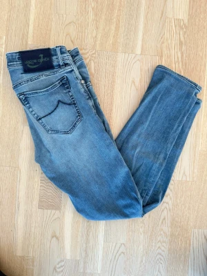 Blå jeans från Jacob Cohen - Snygga ljusblå jeans från Jacob Cohen med klassisk femficksmodell och mörk kontrastsöm på bakfickan. Jeansen har normal passform och är tillverkade i mjuk bomullsdenim som ger en avslappnad look. Size 32, modell 688 c. Frågor kom pm, allt gott/ Neo💫