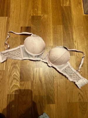 Rosa push up bh - En ljus rosa pushup bh för v-necks. Den är i storlek 70/C och har fyra spännen. Den år nästan aldrig använd och har inga tecken på användning.