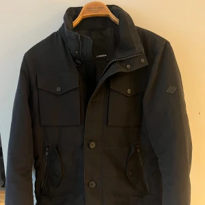 J.lindeberg jacka - Säljer nu en otroligt snygg och eftertraktad jacka från märket ”J.lindeberg”. En lite tjockare och varmare modell av den kända ”bailey” modellen och passar bättre för vintern. Jackan är i färgen svart. Nypris ligger på ca 3,400. Priset är inte hugget i sten!