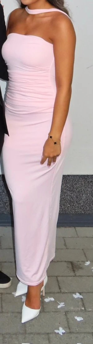 Ljusrosa axelbandslös långklänning - Säljer en elegant ljusrosa långklänning med axelbandslös design och matchande choker-detalj. Klänningen har en figurnära passform och är tillverkad i ett mjukt, stretchigt material som sitter snyggt mot kroppen. Perfekt för dig som vill ha en stilren och feminin look. Storlek XS