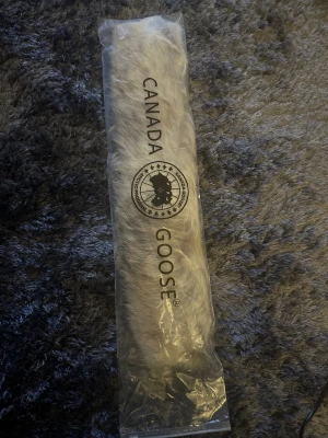 Canada Goose päls till jacka - Säljer en äkta beige päls till Canada Goose jacka, perfekt att fästa på huvan. Pälsen har en snygg ljus ton och kommer med dragkedja för enkel montering. Ger jackan en lyxig och varm vibe, passar dig som vill ha det där lilla extra. 53cm lång fick den till min parka