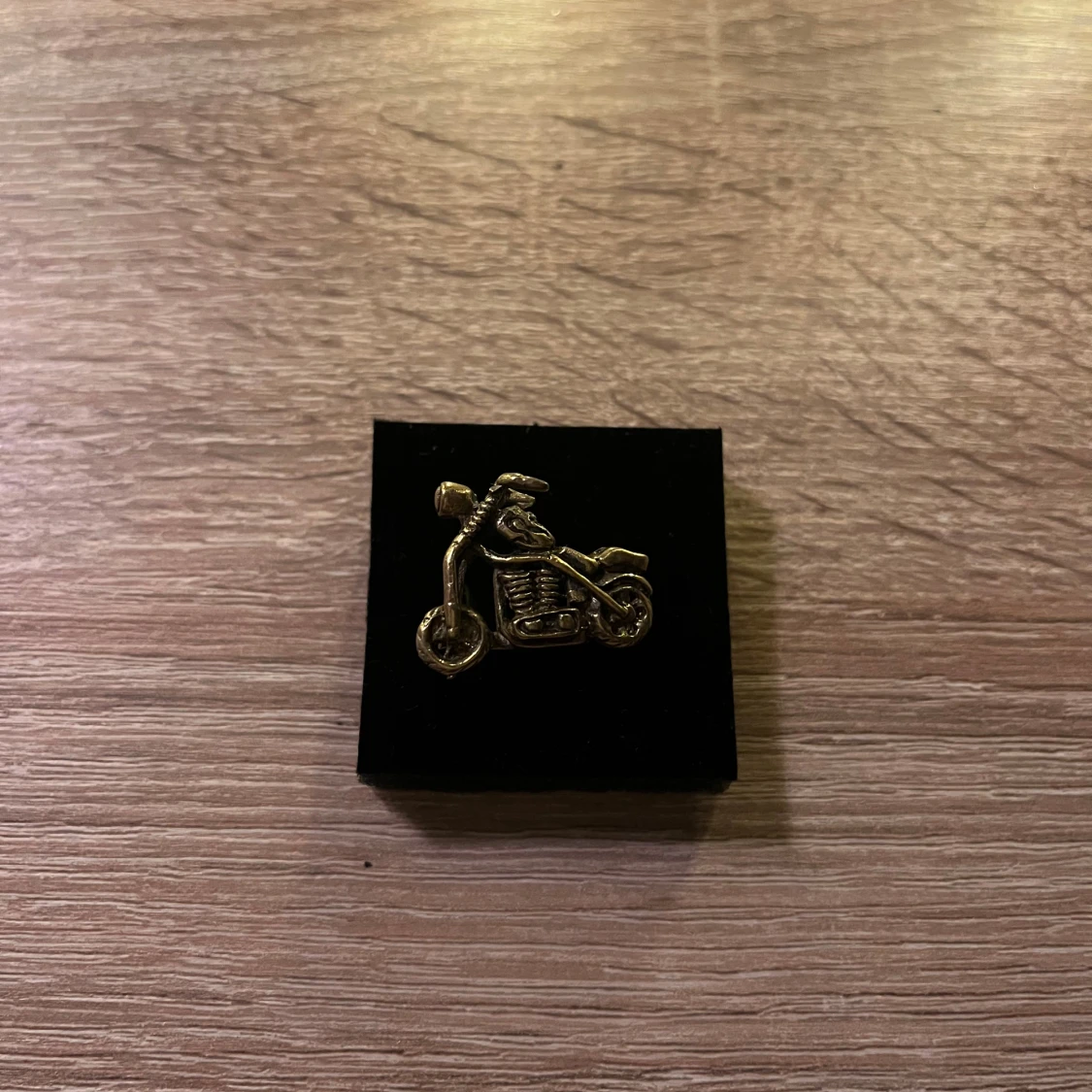 Guldfärgad ring med motorcykel