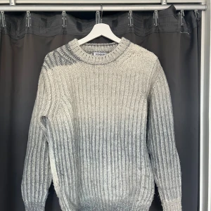 Gråvit stickad tröja från Dondup - Säljer en chunky stickad tröja från Dondup i grått och vitt. Tröjan har bred ribbstickning, rund hals och långa ärmar. Materialet är mjukt och grovt stickat, perfekt för kyliga dagar. Metallogo bak i nacken ger en snygg detalj. Passar dig som gillar stilren och cozy vibe. Köpt för 3000kr ny.