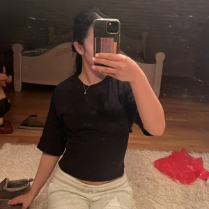 Svart omlottopp med öppen rygg från Nelly - Svart omlottopp från Nelly i storlek XS. Toppen har halvlånga ärmar, croppad passform och snygg öppen rygg med knytband. Tillverkad i mjuk bomull som känns skön mot huden. Perfekt för dig som gillar trendiga detaljer och vill sticka ut. pris går alltid diskutera 