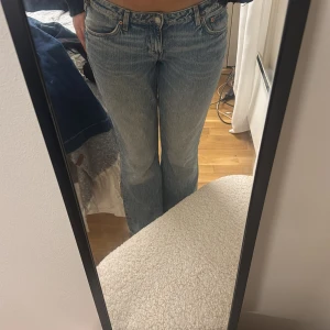 Weekday blå jeans bootcut - Säljer ett par Weekday jeans i ljusblå tvätt med bootcut passform. Byxorna har fem fickor, knappgylf och är tillverkade i slitstarkt jeanstyg. Snyggt vintage-inspirerat utseende och passar perfekt till sneakers eller boots. Använda några fåtal gånger små i storlek 30/34