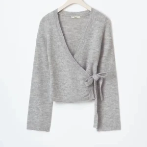 Grå omlottkofta med knyt i sidan - säljer denan jätte fina stickade omlottkoftan som tyvär inte kommer till andvändning längre. den är i bra skick och den är andvänd fåtal gånger ❤️den säljs inte länge från gina 