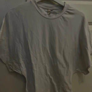 Vit kortärmad t-shirt i bomull - Säljer en enkel vit t-shirt med rund hals och korta ärmar. Modellen är figurnära och har en clean look som funkar till jeans eller shorts. Materialet är mjuk bomull och t-shirten har en klassisk passform.