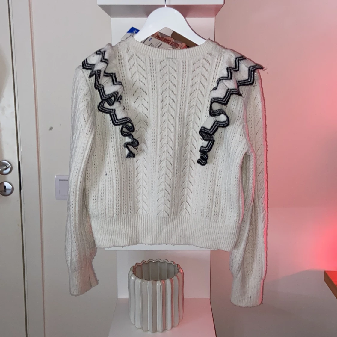 Vit stickad tröja med svarta volanger