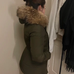 Olivgrön dunjacka Woolrich med päls - Säljer en olivgrön dunjacka från Woolrich med fluffig päls runt huvan. Fin passform vid midjan, pris kan diskuteras!❤️