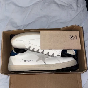 Golden Goose vita sneakers med stjärna - Vit/Grå/Mörkblåa Golden Goose skor, Riktigt snygga o clean design med lyxig känsla. Asfräscha då de är helt oanvända.  Hör av er vid frågor och funderingar.