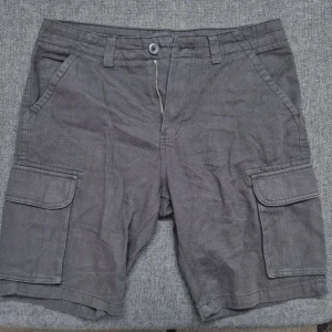 Svarta cargoshorts 157 – stilrena & bekväma (S) - Snygga svarta cargoshorts från 157 i storlek S. Använda endast 1–2 gånger – i princip som nya. Mjukt tyg med lätt vintage-look och praktiska fickor på sidorna. Perfekta för sommaren, vardags, streetwear eller casual fit. Passar dig som vill ha enkla men stilrena shorts med bra passform och bekväm känsla.   Snabb leverans  Öppet för bud / paketpris vid flera köp  Storlek: S  Passform: Normal  Skick: Mycket bra (använda 1–2 gånger)