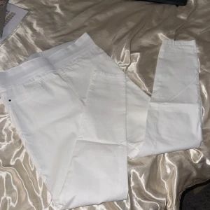 vita stretchiga byxor  - Vita byxor med hög elastisk midja, långa och har en fin och tajt passform. Passar både M, L och XL på grund av stretchen, superfina !