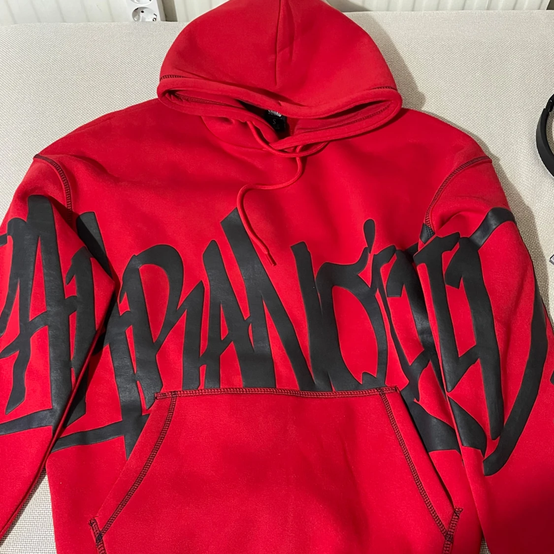 Röd hoodie med svart graffiti-tryck