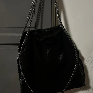 Svart axelväska med kedjedetaljer - Snygg svart axelväska