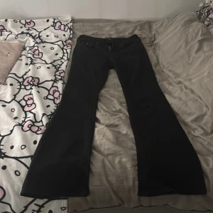 Svarta True Religion bootcut jeans - Säljer ett par svarta jeans från True Religion, modell Becca Mid Rise Bootcut. Jeansen har klassiska fickor med knapp bak, snygga sömmar och en bootcut passform som ger en schysst siluett. Materialet är jeans och midjan är midwaist. Dem är lite urtvättade som ni ser det är därför de är  ljusa på vissa ställen. Dem är inte jätte använda och därför skulle jag inte säga att de är jätte slitna. Jag tycker att längden är bra (är 164 cm lång) men i midjan sitter dem lite lite stort på mig. Passa på!