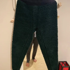 Svarta teddybyxor från  ts -produkter - Mysiga svarta teddybyxor från  ts -produkter, tillverkade i Sverige. Byxorna har en fluffig och grov struktur, resår i midjan och är perfekta för kalla dagar. Materialet är 70% polyester och 30% polyacryl för extra värme och komfort.