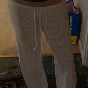 Vita virkade byxor från Gina Tricot XS - Säljer ett par vita virkade byxor från Gina Tricot i storlek XS. Byxorna har dragsko i midjan och är tillverkade i återvunnen polyester. De har en loose passform och är perfekta för en chill och trendig look.